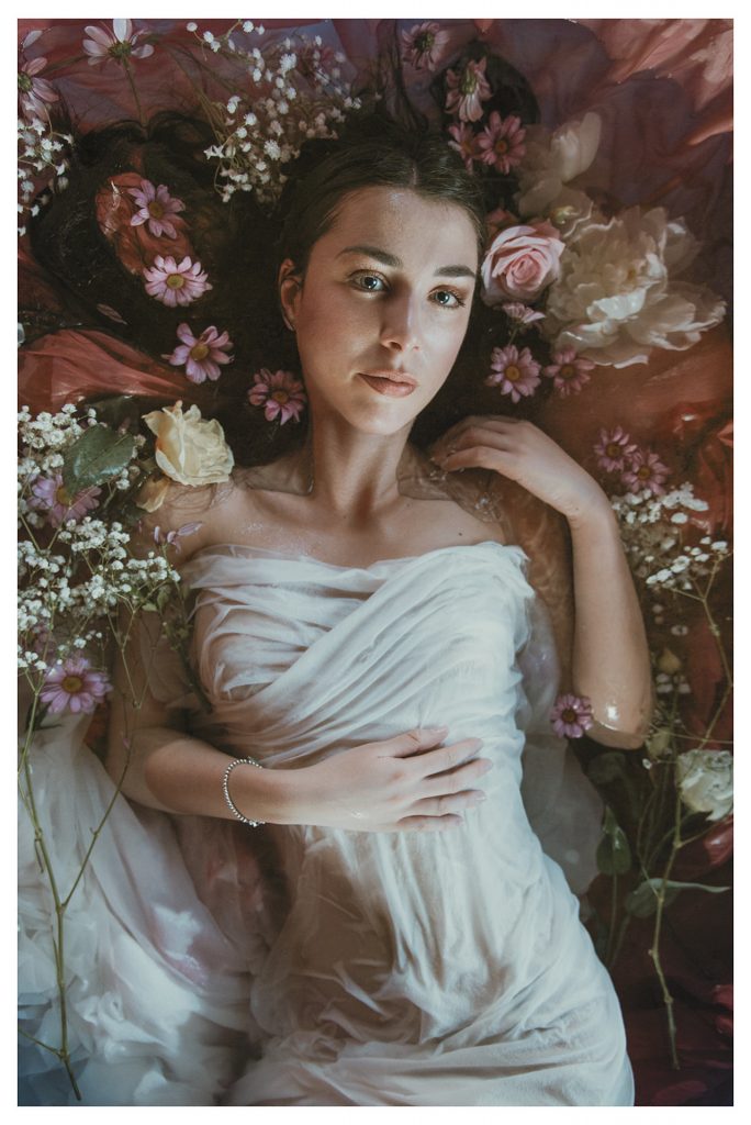 modella posa in una vasca piena di fiori | fotografia come un quadro